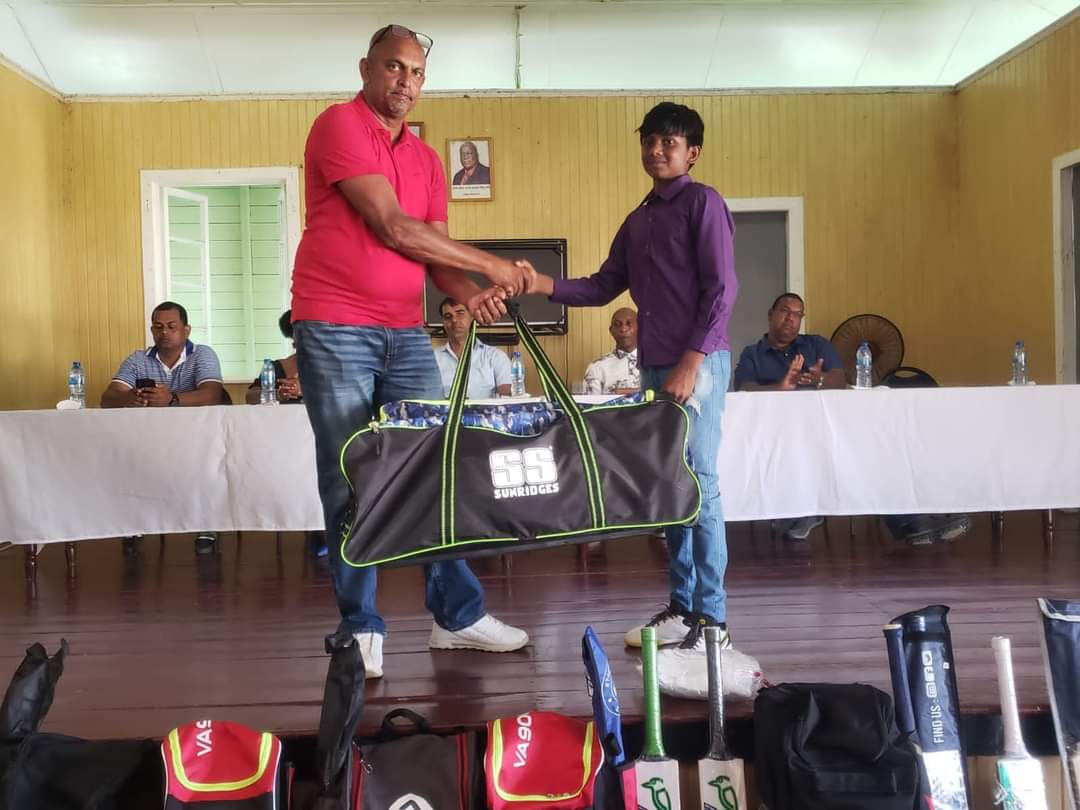 One of the Albion youngsters receiving their cricket bag from Fabian Naiken.Â