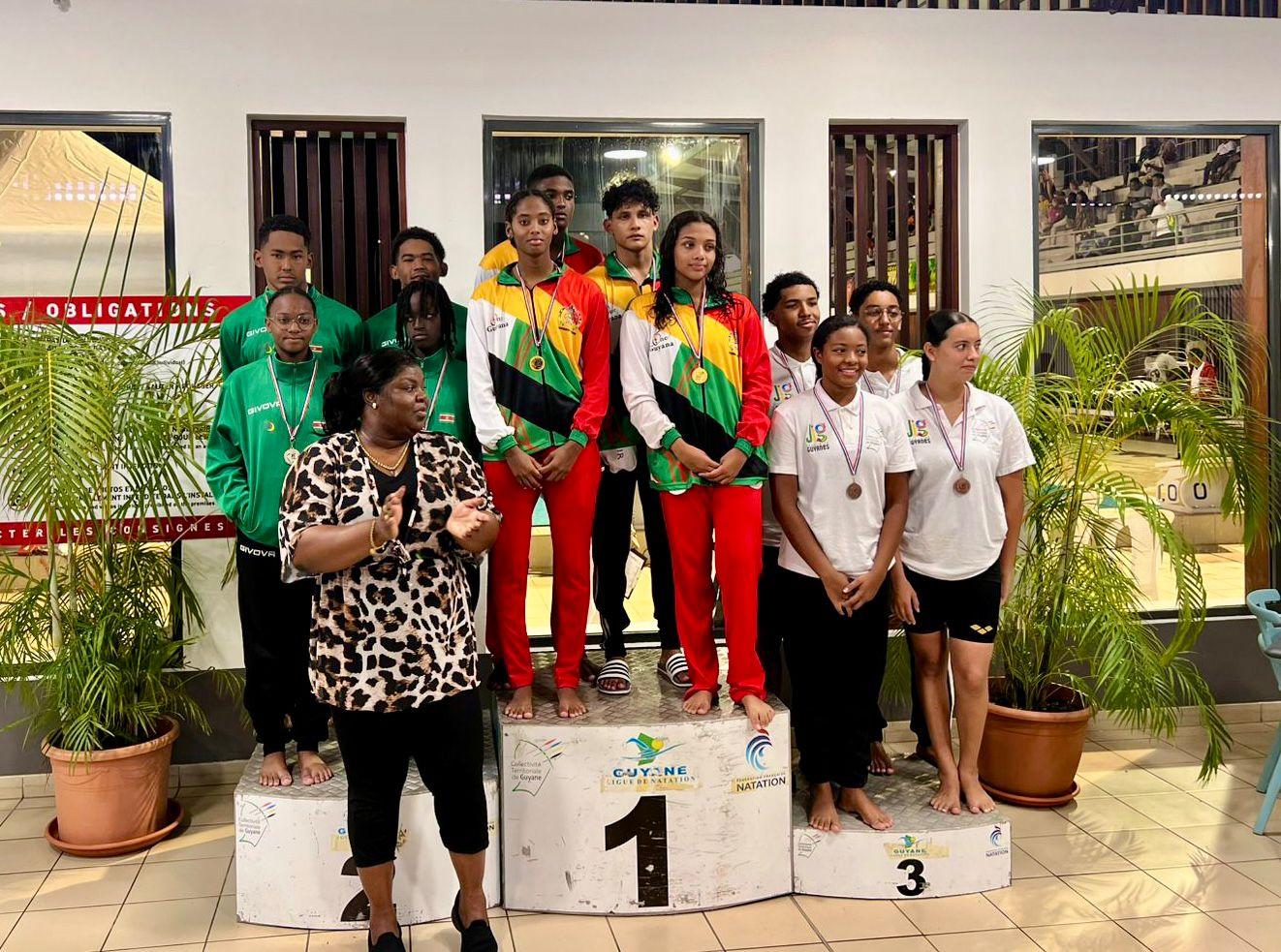Team Guyana standing on the podium awaiting their medals after winning the Mixed relay in swimming.